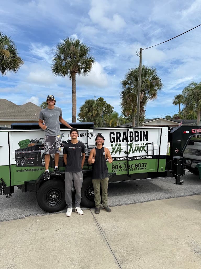Grabbin Ya Junk crew standing in front of their branded junk removal trailer